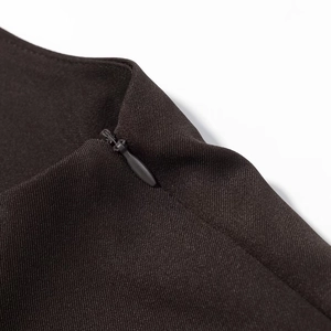 Dettaglio della cerniera invisibile e tessuto twill scuro su un abito da vacanza