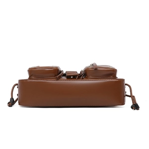 Detail view of brown biker bag with metal eyelets, zippers and functional drawstrings