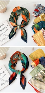 Detail of pleated silk scarves featuring vibrant floral patterns and textured crinkle finish