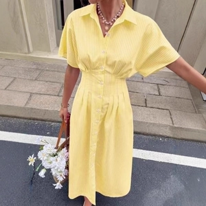Detail of yellow striped shirt dress featuring button-down front and waist-cinching cut