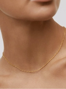 Close-up of minimalist gold square pendant necklace on model showcasing delicate chain texture