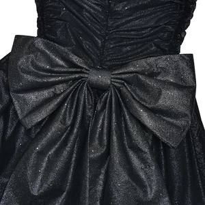 Close-up of the large bow detail on the back of a slim black glittery evening dress