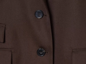 Detail of dark brown twill blazer with black four-hole buttons and pocket stitching