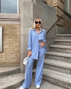 Detail of light blue pleated fabric texture on long sleeve shirt and wide leg pants set