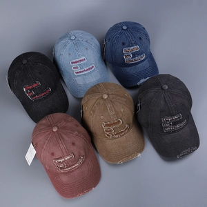 Detail showing distressed denim baseball caps with embroidery and frayed edges in six colors