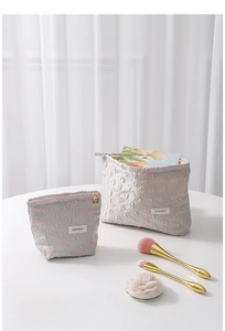 Detail of floral embossed cosmetic bags showing textured fabric and delicate pink blossoms