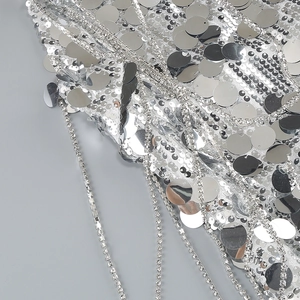 Macro shot of silver sequins and rhinestone chain details on the evening dress fabric
