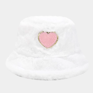 Close-up of white plush bucket hat featuring pink glitter heart patch and soft faux fur texture