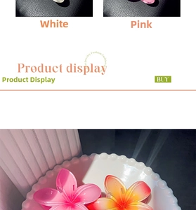 Close-up of frangipani flower hair claw clips in white and pink resin on a ceramic plate