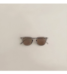 Vue détaillée des lunettes de soleil rétro pour enfants avec monture grise et verres bruns