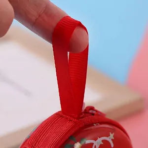 Christmas round tinplate coin purse with a red ribbed ribbon handle and zipper closure