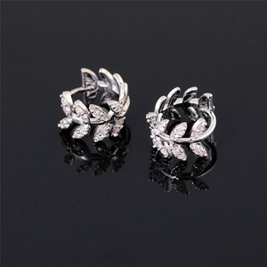 Close-up of silver branch earrings featuring olive leaf design with clear zircon stones