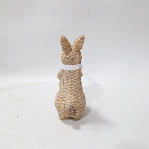 Detail of vintage resin rabbit statue with woven texture and white ribbon bow