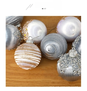 Detailed view of 6cm white foam Christmas balls with gold glitter stripes and sequins