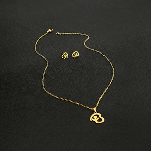 Macro shot of gold-tone hollow heart jewelry set with floral patterns on black leather