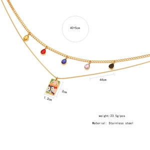 Detailed view of gold double-layer necklace with enamel face pendant and colorful droplets