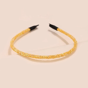 Close-up of golden glitter headband with shiny sequins and black protective tips