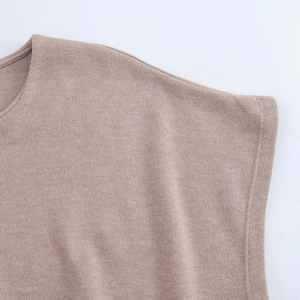 Macro detail of soft khaki knitted top shoulder and fine edge stitching texture