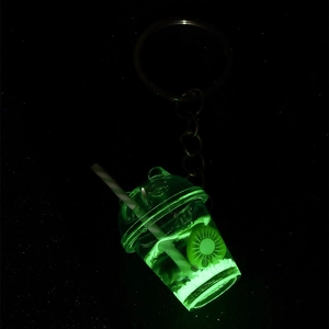 Luminous mini fruit cup keychain glowing bright green in the dark with a metal ring