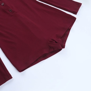 Detail of burgundy ribbed jumpsuit showing square neck with three matching buttons