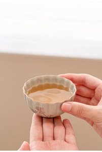 Macro view of a ceramic daisy teacup with petal shaped rim and hand painted flowers
