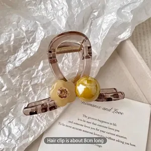 Macro shot of 8cm large amber floral hair claw clip with pearl and rhinestone accents