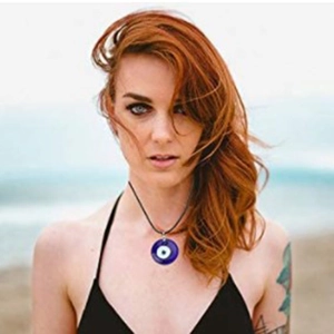 Vue détaillée du pendentif Evil Eye en verre bleu foncé porté par un mannequin