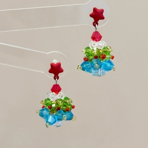 Macro detail of handmade beaded Christmas tree earrings with colorful crystal accents