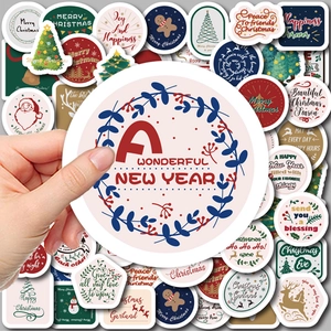 Hand holding vibrant Christmas decorative stickers for scrapbooking and gift wrapping