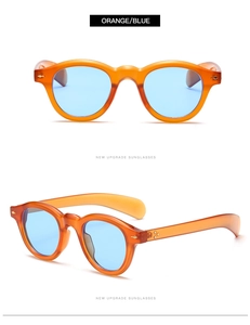 Close-up of retro round orange translucent sunglasses with light blue lenses and metal hinges