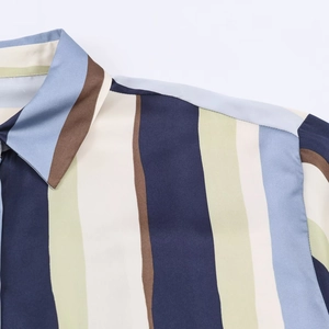 Close-up of lapel collar and shoulder stitching on a multicolored striped satin shirt