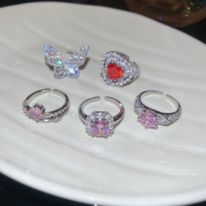Macro shot of silver adjustable rings with zircon butterflies and pink heart gems