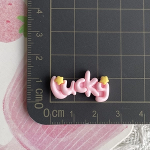 Macro shot of pink resin Lucky charm with star detail showing 2.5cm size measurement
