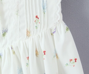 Dettaglio di abito floreale in chiffon con pizzo, tessuto a pieghe e stampe colorate