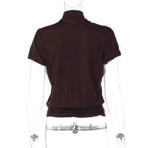 Détail d'un haut marron foncé moulant avec fronces à la taille et texture soyeuse