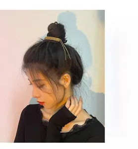 Macro shot of gold twist hair bun maker with sparkling tassels and rhinestone details