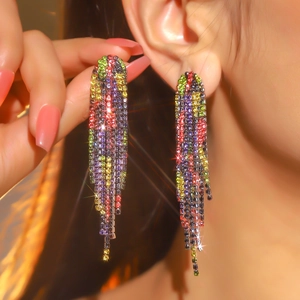 Close-up of luxury long tassel earrings with multicolored rhinestones on model
