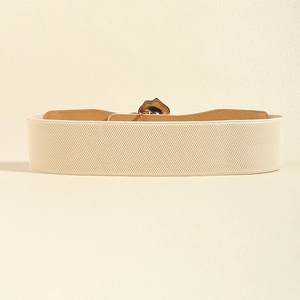 Détail de la ceinture corset élastique beige avec boucle en métal doré texturé