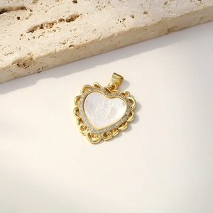 Golden heart pendant with carved shell Virgin Mary and zircon stones on beige stone