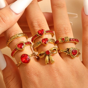 Macro view of vintage gold-plated rings with red heart stones and bow details