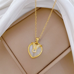Detailed view of a gold heart pendant necklace with center stone and sparkling zircons