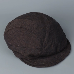 Detailed top view of a dark charcoal linen newsboy cap with vintage stitching details