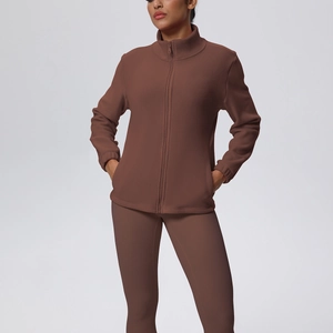 Dettaglio del set yoga in pile marrone con giacca con zip e leggings a vita alta