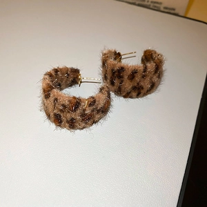 Detailed close-up of leopard print flocking C-hoop earrings with golden metal studs