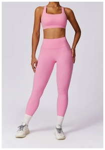Front full view of a pink high-waist yoga set with racerback top and leggings on a model