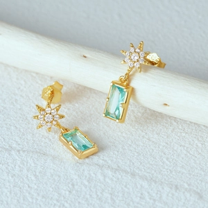 Detailed view of S925 stamped gold-plated earring with star zircon and green gemstone