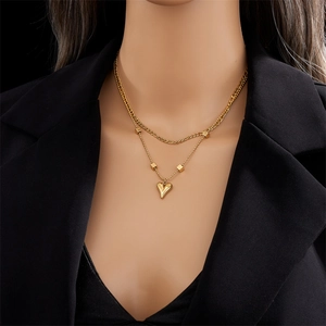 Collier chic double rang en titane doré avec pendentifs cœur et carré sur un mannequin