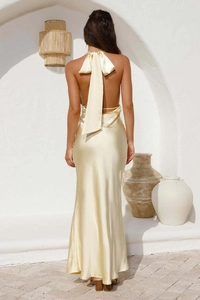 Détail du dos de la robe en satin jaune clair dos nu avec un grand nœud élégant au dos