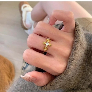 Close-up of a vintage gold cross ring with a white zircon worn on a hand