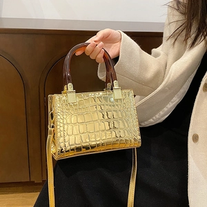 Chic gold crocodile pattern handbag with amber resin handles and crossbody strap